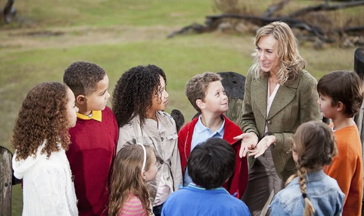 teacher talking to a group of students on a field trip