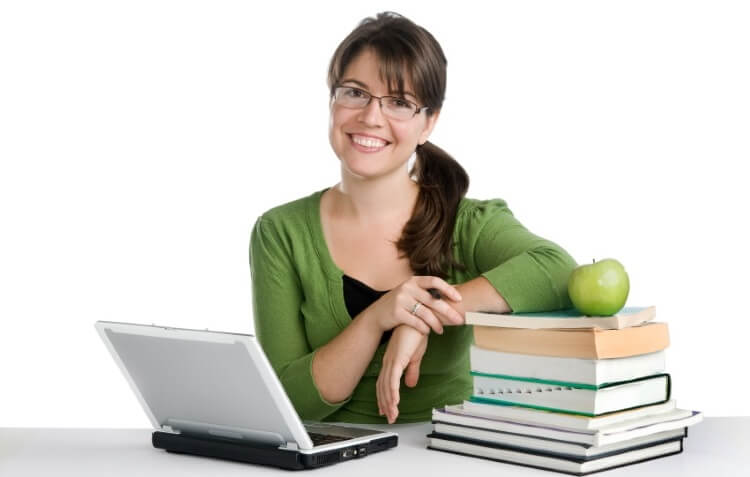 female teacher with laptop and bunch of books