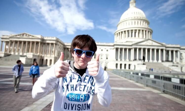 young student in front of White House giving thumbs up