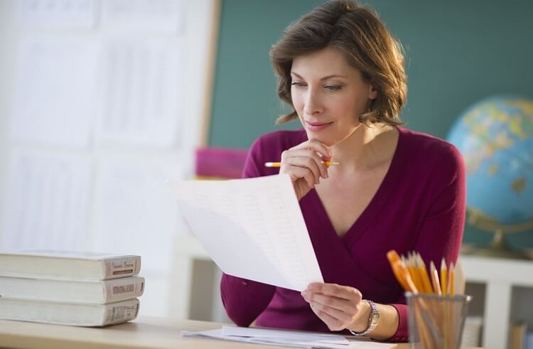 woman teacher studying something on paper