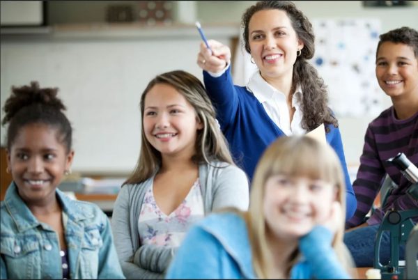 a smiling female teacher in her classroom