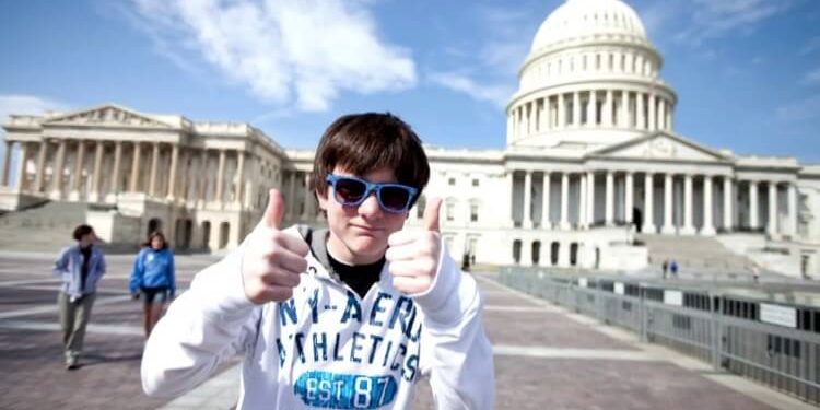 young student in front of White House giving thumbs up