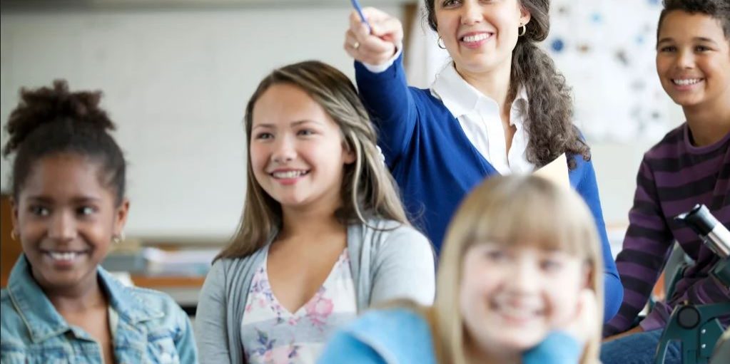 a smiling female teacher in her classroom