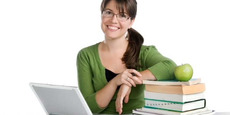 female teacher with laptop and bunch of books